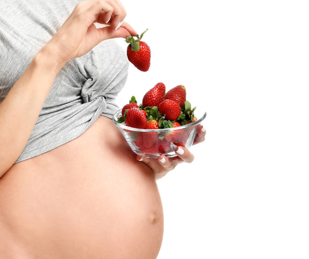 Bella donna incinta con grande pancia mangiare fragole
 - Foto, immagini