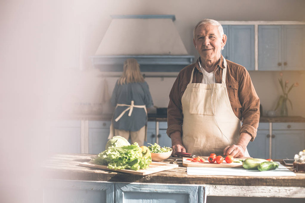 Happy mature man preparing healthy food with woman - Фото, изображение