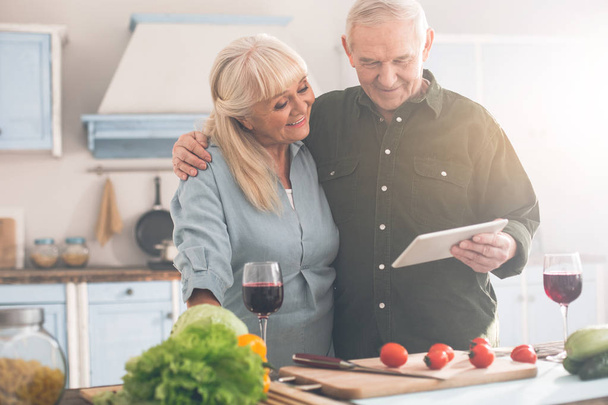 Happy pensioners spending leisure time in kitchen - Fotografie, Obrázek