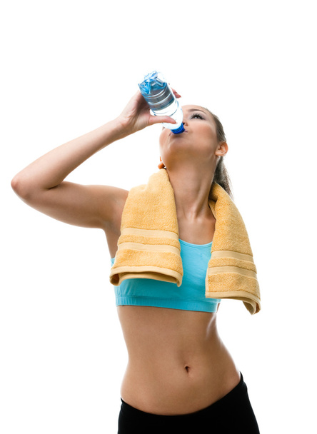 Sportive woman drinks water from the bottle - Fotó, kép