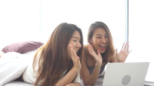 Yavaş hareket - yatak sarılmak üzerinde oturan ve evde laptop birlikte yatak odası kullanarak güzel genç Asyalı kadınlar Lgbt lezbiyen mutlu çift. Lezbiyen birlikte kapalı kavramı çift. Evde güzel vakit. - Video, Çekim