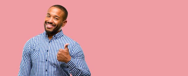 Uomo afroamericano con la barba sorridente ampiamente mostrando pollici verso l'alto gesto alla macchina fotografica, espressione di come e approvazione
 - Foto, immagini