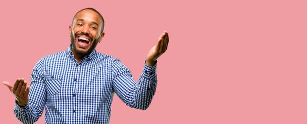 African american man met baard zelfverzekerd en blij met een grote natuurlijke glimlach Welkom gebaar - Foto, afbeelding
