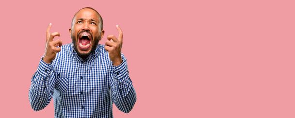 Uomo afroamericano con barba terrorizzato e nervoso che esprime ansia e gesto di panico, sopraffatto
 - Foto, immagini
