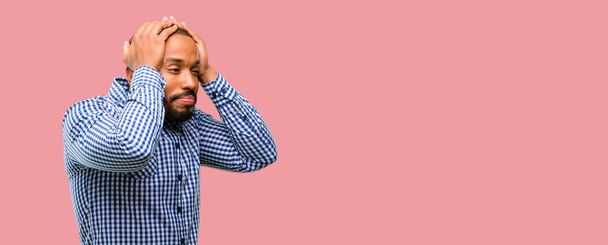 afrikanisch-amerikanischer Mann mit Bart, der lästige laute Geräusche ignoriert, verstopft Ohren, um Geräusche zu vermeiden. Laute Musik ist ein Problem. - Foto, Bild