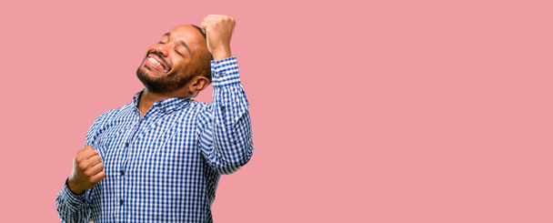 Homme afro-américain avec barbe heureux et excité exprimant geste gagnant. Victoire réussie et célèbre, triomphante
 - Photo, image