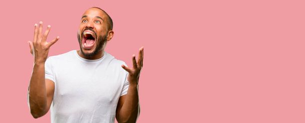 African american man with beard happy and surprised cheering expressing wow gesture - Fotoğraf, Görsel