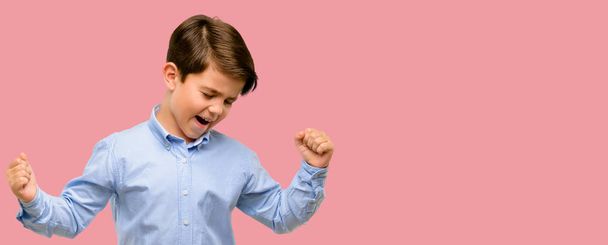 Όμορφος νήπιο παιδί με πράσινα μάτια, χαρούμενος και συγκινημένος εκφράζοντας κερδίζοντας χειρονομία. Επιτυχής και γιορτάζει τη θριαμβευτική νίκη - Φωτογραφία, εικόνα