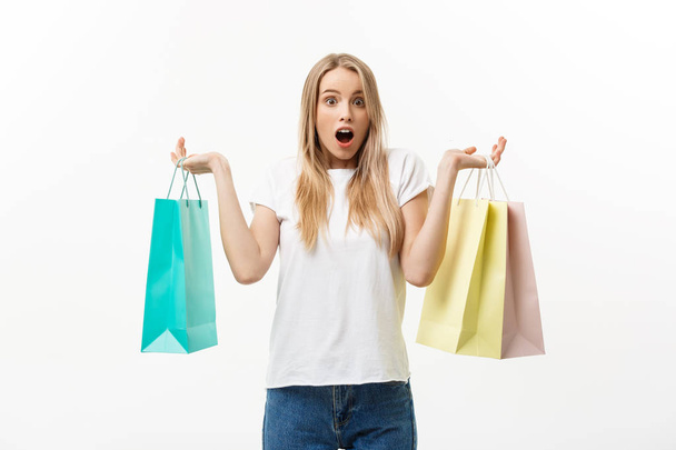 Lifestyle Concept: Portrait shocked young brunette woman in white summer shirt posing with shopping bags isolated over white background. - Valokuva, kuva
