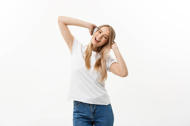 Lifestylekonzept: Porträt einer fröhlichen Studentin, die mit Kopfhörern Musik hört, während sie isoliert vor weißem Hintergrund tanzt - Foto, Bild