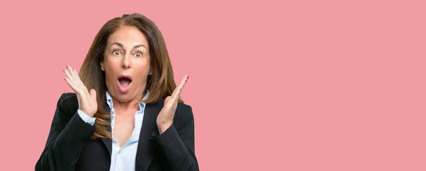 Middle age business woman happy and surprised cheering expressing wow gesture - Photo, Image