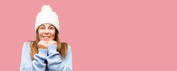 Женщина средних лет в шерстяной зимней шапочке в ужасе и нервном выражении тревоги и панического жеста, перегружена
 - Фото, изображение