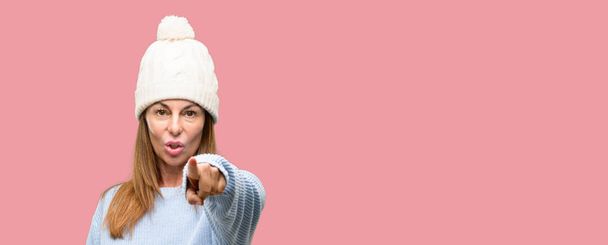 Middle age woman wearing wool winter cap pointing to the front with finger - Foto, Imagem