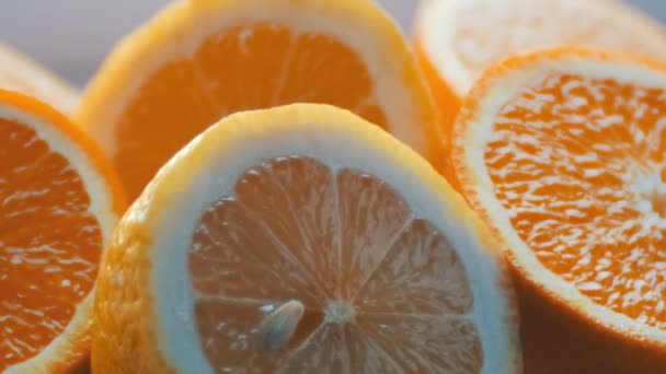 Gesneden citrus citroen en sinaasappel vergrote weergave sluit op een witte achtergrond - Video