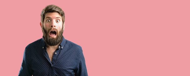 Giovane hipster uomo con grande barba felice e sorpreso tifo esprimendo gesto wow
 - Foto, immagini