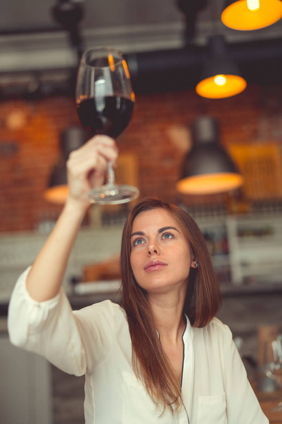 Молодая женщина с бокалом вина в помещении
 - Фото, изображение