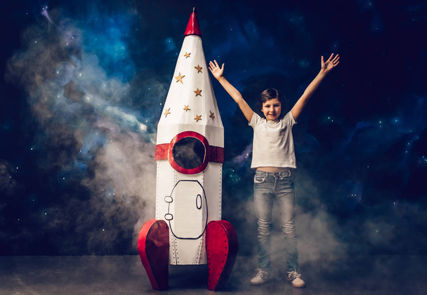 Boy with toy rocket in space - Foto, afbeelding