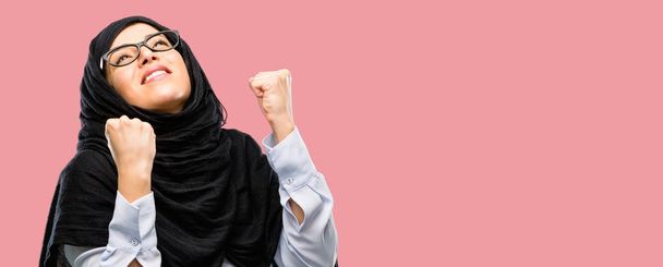 Αραβικά γυναίκα φοράει μαντίλα χαρούμενος και συγκινημένος γιορτάζουμε νίκη εκφράζοντας την μεγάλη επιτυχία, δύναμη, ενέργεια και θετικά συναισθήματα. Γιορτάζει χαρούμενη νέα δουλειά - Φωτογραφία, εικόνα