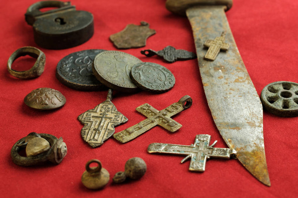 багато стародавніх мідних і залізних предметів на червоному тлі, особисті речі XVIII століття, знайдені в землі
 - Фото, зображення