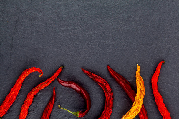 Red hot chili peppers on black background. Free space for text . Top view - 写真・画像