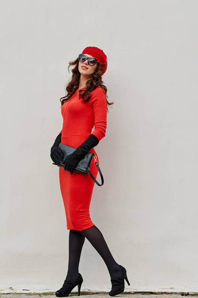 charm woman in red dress about the wall - Zdjęcie, obraz