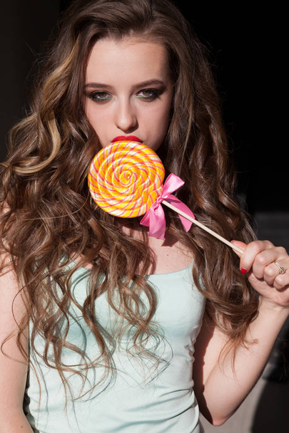 женщина ест сладкие конфеты леденец
 - Фото, изображение