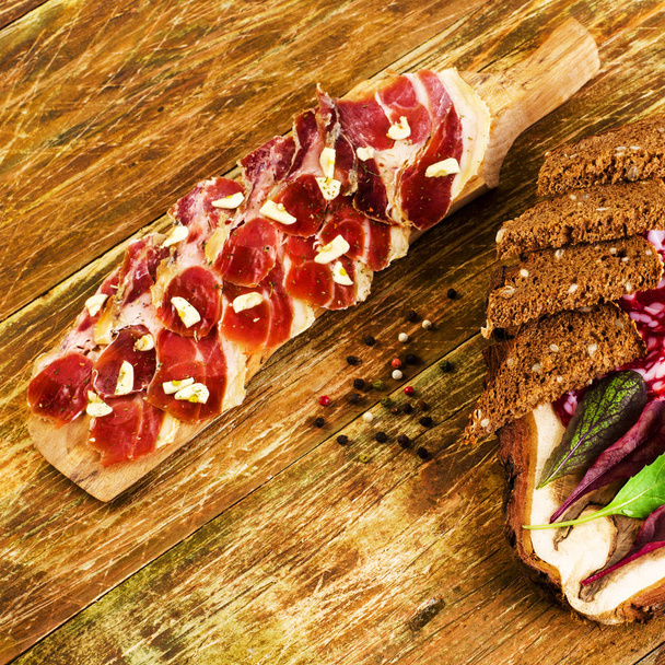 Prkénko, chléb, slaninu a česnek na dřevěné pozadí. T - Fotografie, Obrázek