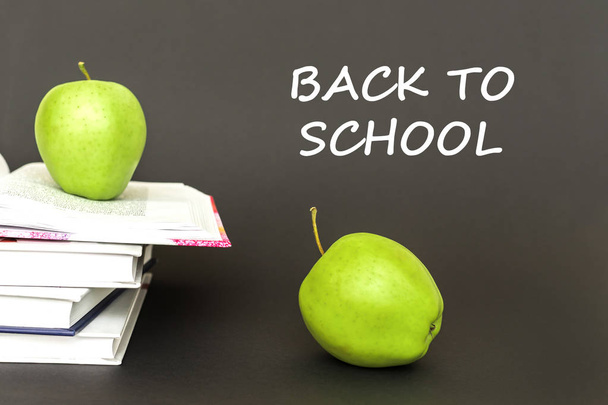 Text zurück zur Schule, zwei grüne Äpfel, offene Bücher mit Konzept - Foto, Bild
