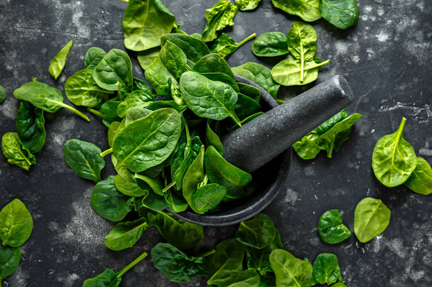 Fresh organic spinach leaves in marble pestle ready for pesto making - Foto, afbeelding