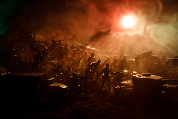 Concepto de guerra. Siluetas militares peleando escena en el fondo del cielo niebla de guerra, Soldados de la Guerra Mundial Siluetas debajo del horizonte nublado Por la noche. Escena de ataque. Vehículos blindados. Enfoque selectivo. Decoración
 - Foto, imagen
