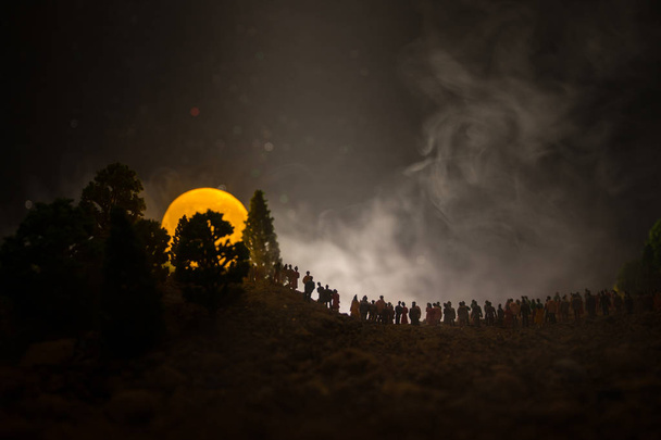 Silhouette d'une grande foule de personnes dans la forêt la nuit regardant à la pleine lune levante. Fond décoré avec ciel nocturne avec étoiles, lune et éléments d'espace. Concentration sélective. Monde surréaliste
 - Photo, image