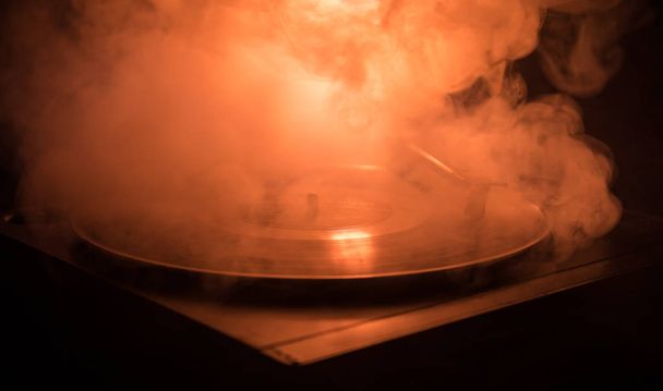 ターン テーブル ビニール レコード プレーヤー。ディスク ジョッキーのレトロなオーディオ機器。Dj ミックス ・音楽を再生するためのサウンド テクノロジー。煙と火の背景の書き込みに対して再生されてビニール レコード - 写真・画像