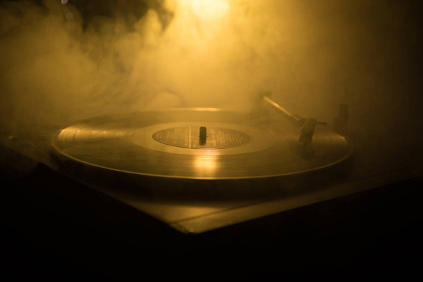 ターン テーブル ビニール レコード プレーヤー。ディスク ジョッキーのレトロなオーディオ機器。Dj ミックス ・音楽を再生するためのサウンド テクノロジー。煙と火の背景の書き込みに対して再生されてビニール レコード - 写真・画像