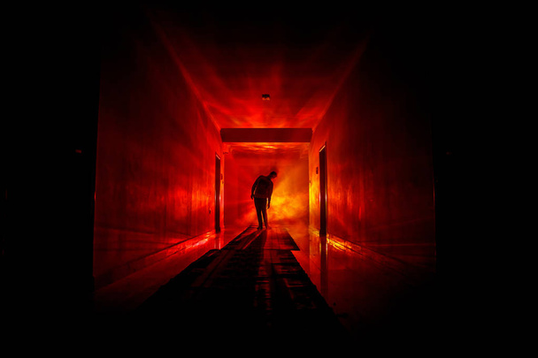 Жуткий силуэт в темном заброшенном здании. Темный коридор с дверями шкафа и огнями с силуэтом жуткого человека ужаса, стоящего в разных позах
. - Фото, изображение