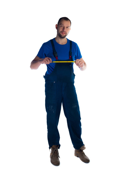 Portrait of a young plumber standing on white background - Photo, Image