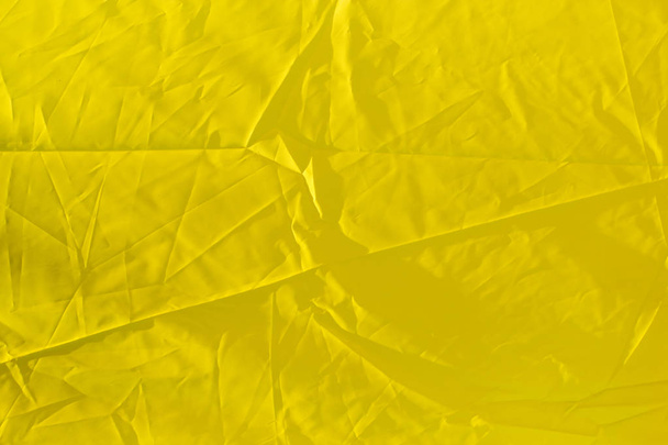 wrinkled yellow cloth as background - Foto, afbeelding
