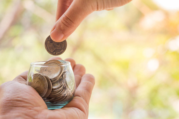 Χέρι του γυναικείου βάζοντας κέρματα στο βάζο με χρήματα βήμα στοίβα αυξανόμενη ανάπτυξη εξοικονόμηση χρημάτων - Φωτογραφία, εικόνα