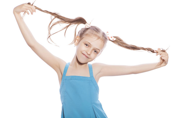 Giovane ragazza bruna di sette anni in abito blu su uno sfondo bianco isolato. Sorridi ed emozioni felici sul suo viso. Ragazza perdere due denti anteriori
 - Foto, immagini
