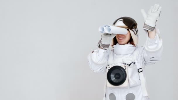 Ritratto di un astronauta divertente, che guarda in lontananza in un telescopio. su sfondo bianco
. - Filmati, video