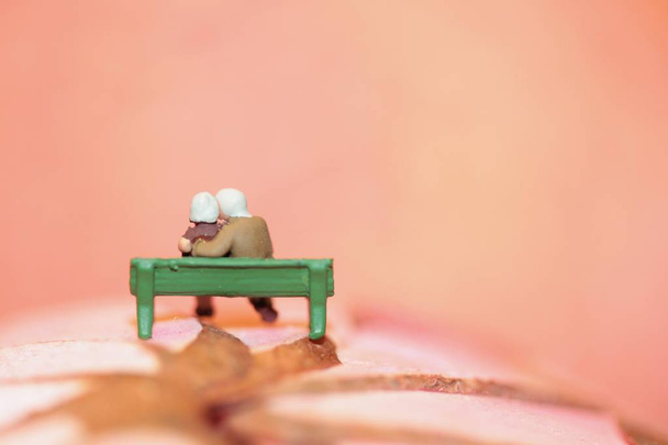 miniatura de una pareja de ancianos enamorados sentados en un banco
 - Foto, Imagen