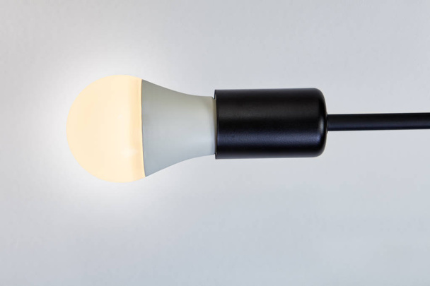 Bulb holder with black metal extension and LED lamp. - Fotó, kép