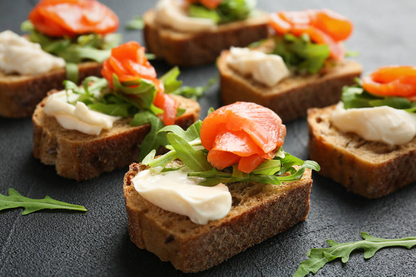 Tasty sandwiches with fresh sliced salmon fillet on table - Photo, Image