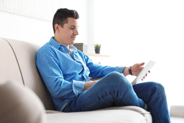 Portrait of man with laptop on sofa, indoors - Foto, Imagen