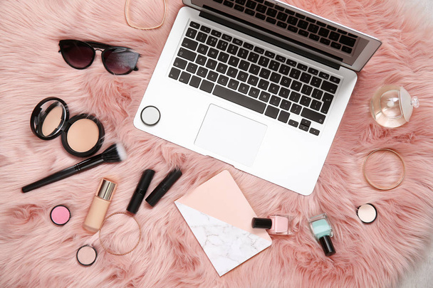 Flat lay composition with laptop, notebook and makeup products for woman on fur - Photo, Image