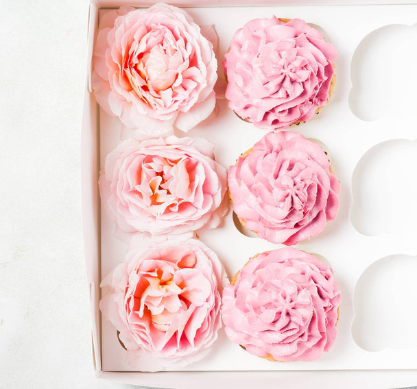 Pink cupcakes with roses in box. Festive and bright. Wedding Celebration concept. top view, flat lat - Foto, immagini