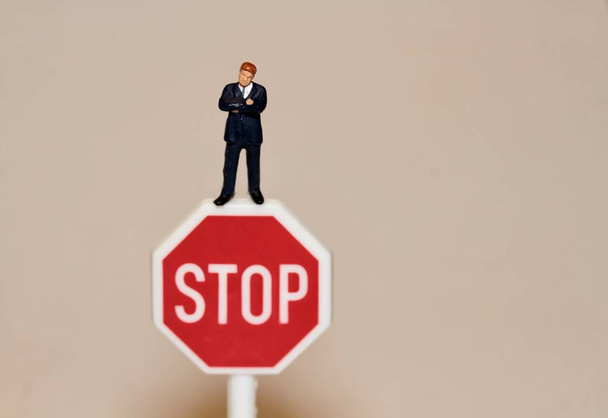 miniatura hombre de negocios con una señal de stop
 - Foto, imagen