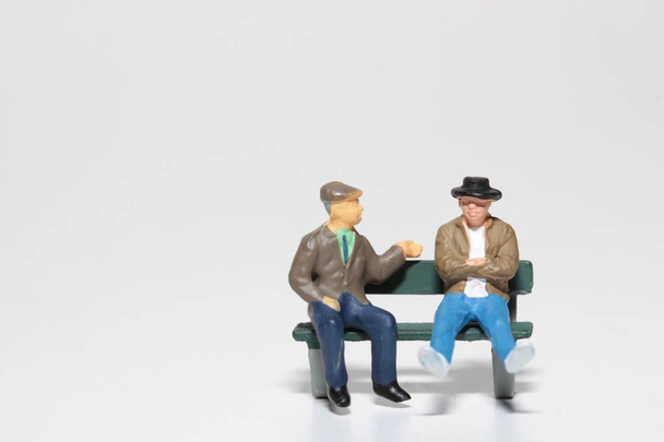 miniaturowe osób wypowiadających się na ławce - Zdjęcie, obraz