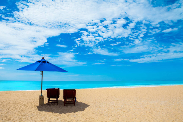 Ξαπλώστρες και ομπρέλες σε μια όμορφη παραλία και την μπλε του ουρανού - Φωτογραφία, εικόνα