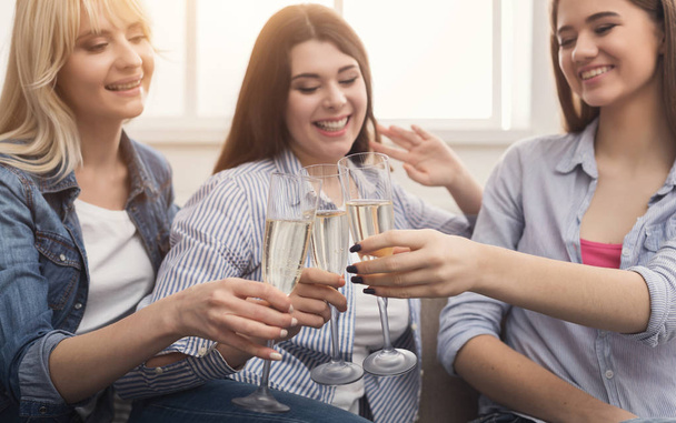 Kolme nuorta naispuolista ystävää juo samppanjaa
 - Valokuva, kuva