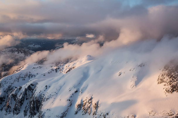 Striking aerial landscape view of the beautiful Canadian Mountains during a dramatic sunset. Taken North of Vancouver, British Columbia, Canada. - Foto, Imagen